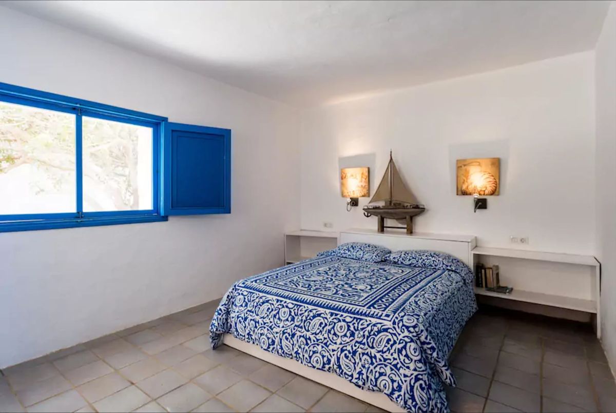 Dormitorio con colcha azul y blanca