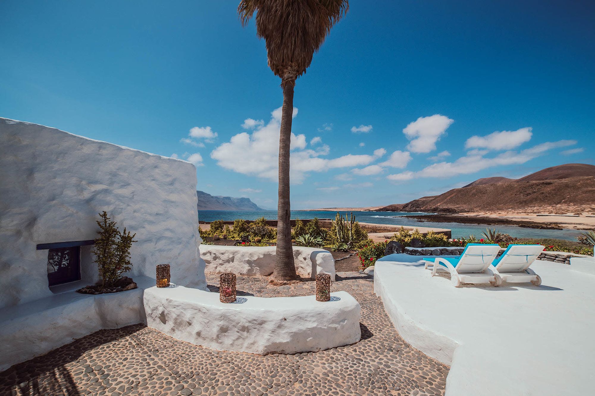 Terraza blanca de Seaside Villa con palmera y vistas al mar y a Lanzarote