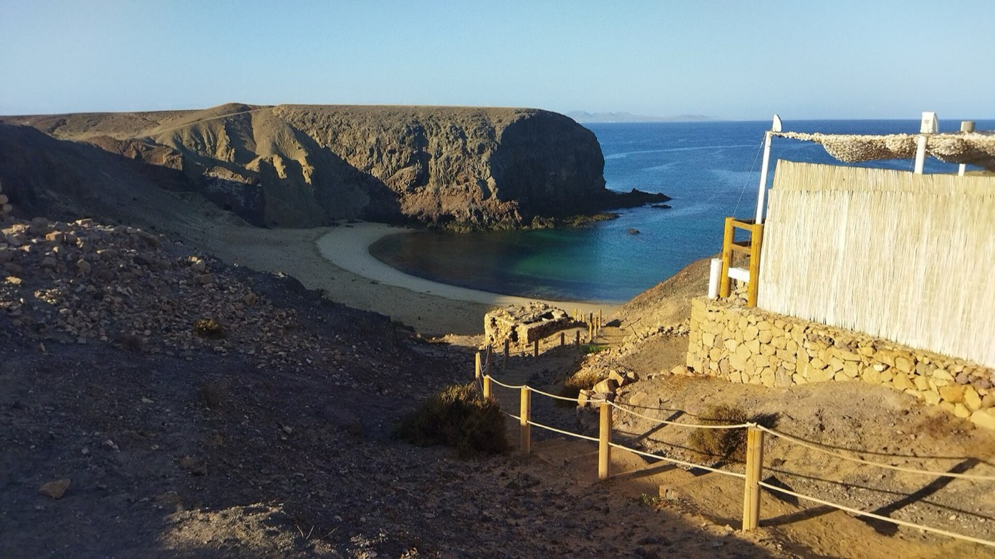 Cala de Papagayo con arena dorada y agua turquesa entre acantilados