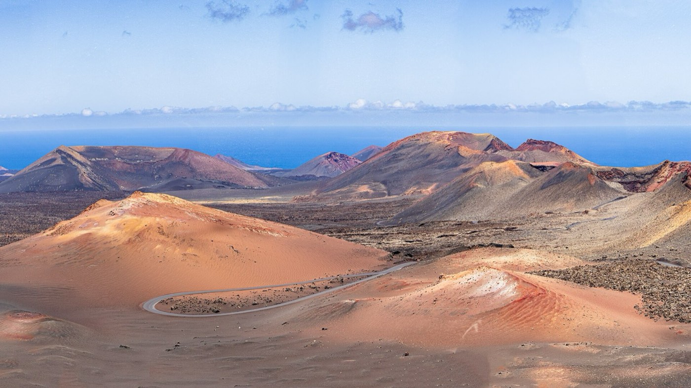 Volcanes rojizos y ocres del Parque Nacional de Timanfaya con el mar al fondo