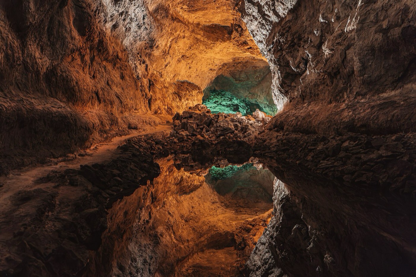 Interior de la Cueva de los Verdes con roca volcánica iluminada en tonos ocres
